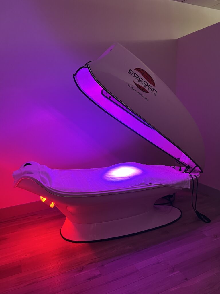 Open Cocoon Fitness Pod providing full-body heat and vibration therapy.
