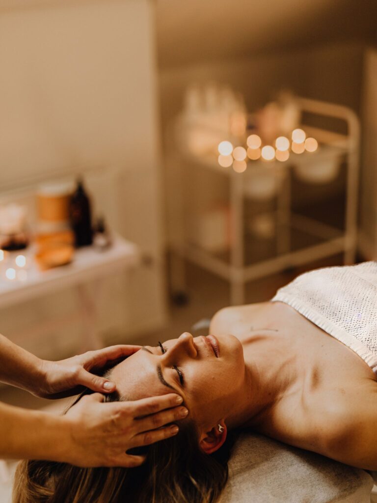 Holistic esthetician performing a facial treatment using organic products and advanced skin therapy.